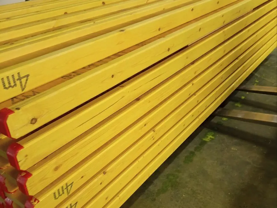 Finished girders stacked in a workshop, marked with their length