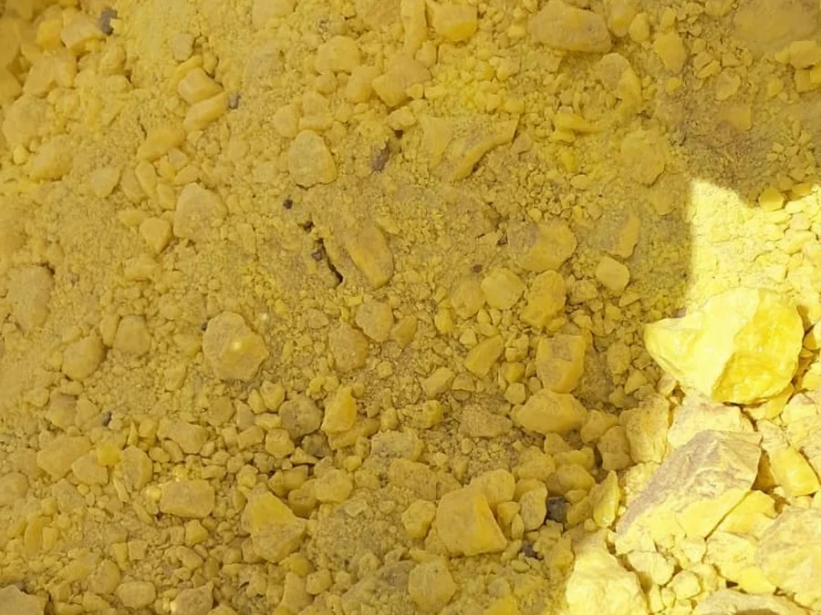 Close view of crushed lump sulphur mixed with fines and dust in a bag
